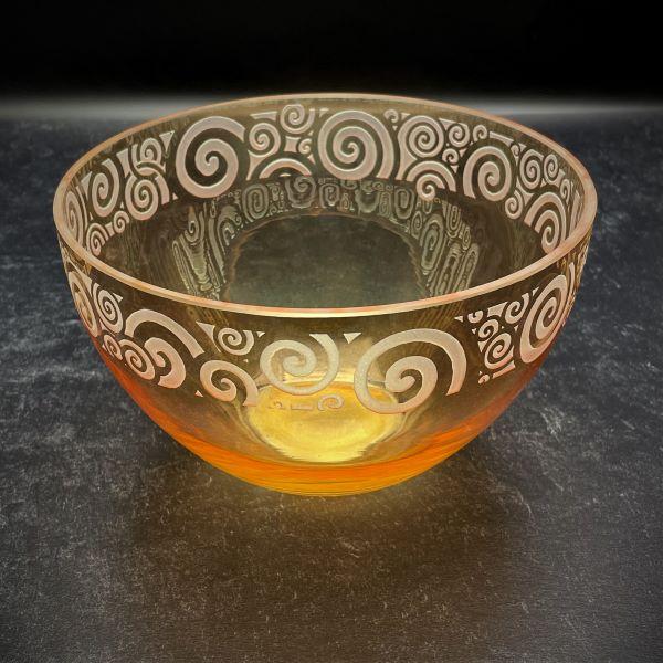 Irridescent-peach-bowl-with-spiraling-out-of-control-sandblasted-design-black-background-top-view 