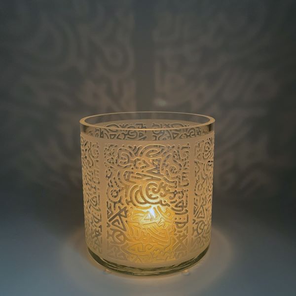 Clear-candle-holder-with-sandblasted-doodles-design-with-lit-tealight-candle-Its-A-Blast-Glass