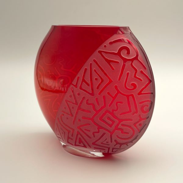 Red medium flat round glass vase with sandblasted Geo Abstract design slanted side view 