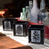 Pinecone-black-blown-glass-candle-holders-on-table-with-bottles-Its-A-Blast-Glass-Tucson