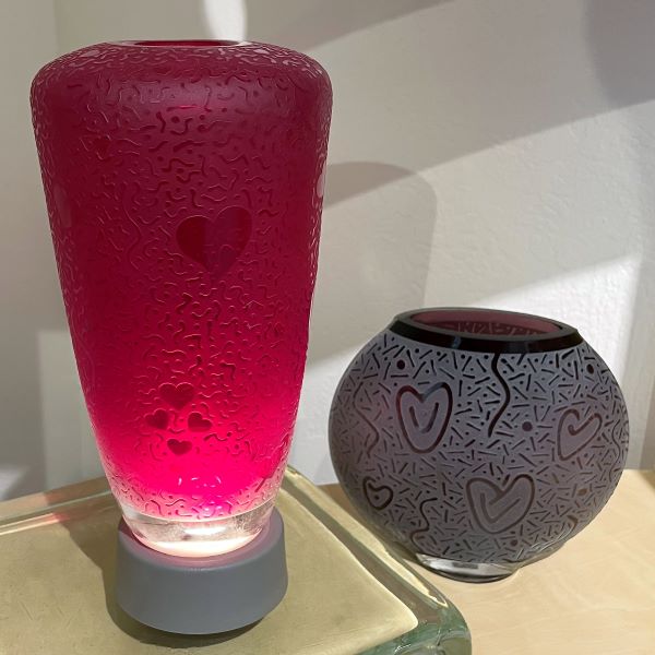 Red-handblown-glass-vase-with-sandblasted-hearts-abound-design-light-stand-with-purple-round-vase 